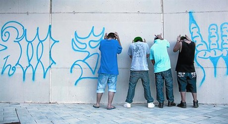 Quatre membres de la Mara 13 fan la salutaci� del grup al costat de pintades de la banda a la carretera de Collblanc de l'Hospitalet, abans-d'ahir.