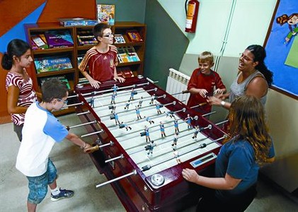 Uns nens juguen amb la seva monitora en un local de la Fundaci� Catalana de l'Esplai a l'Hospitalet de Llobregat, ahir.