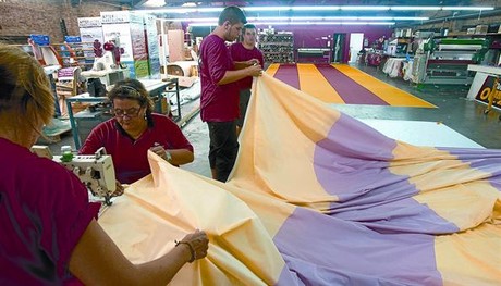 La confecci� 8 Els treballadors de l'empresa Marc Mart�, en ple proc�s de fabricaci� de la senyera que ahir va presidir la manifestaci�.