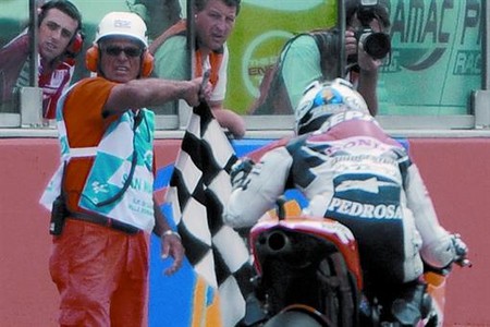 Pedrosa travessa la meta amb el puny al�at, al costat de la bandera de quadros, com a vencedor del GP de San Marino.