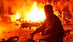 Un policia retira la seva motocicleta del lloc en qu� un grup de manifestants pakistanesos van provocar un incendi. La multitud va reaccionar d'aquesta manera despr�s de la detonaci� d'una bomba davant d'una mesquita a Lahore.