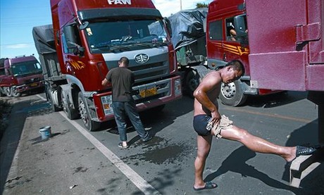  Un camioner es renta enmig de l'enorme emb�s, a la prov�ncia de Hebei, ahir.