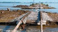 Un home s'agafa a una malmesa via de tren per travessar una riuada sense ser arrossegat per les aig�es a 50 quil�metres de la localitat de Sukkur, a la prov�ncia pakistanesa de Sindh.
